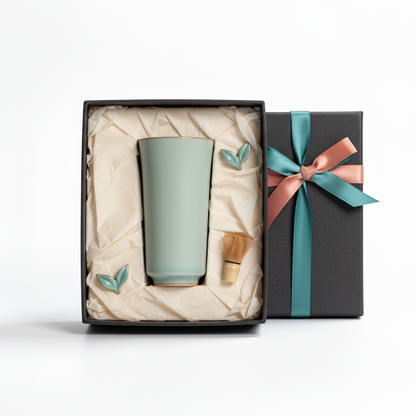 Tall pale celadon green ceramic cup arranged in an elegant gift box with teal and coral ribbon