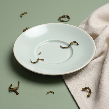 Close-up of the smooth pale celadon glaze and central ring on a ceramic tea saucer