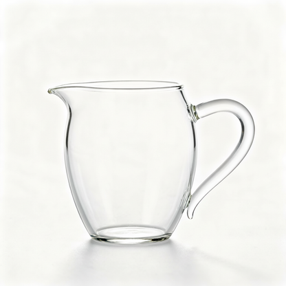 Clear glass water pitcher with rounded body, wide opening, clean spout and curved handle on a white background